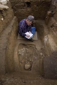 Forensic anthropologist Doug Owsley examines a grave (1726) in the brick Jamestown Church cemetery, in Jamestown, Va. (Photo by Chip Clark)