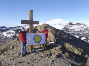 Kristina Johnson and Wayne Clough hoist the Smithsonian flag atop Observation Point. Mount Erebus can be seen in the background.