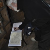 Wayne Clough signs the guest book at the historic Shackleton Hut in Cape Royd.