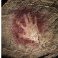 This 30,000-year-old handprint from Chauvet Cave in France, made by mixing pigment with saliva inside the mouth and blowing the mixture onto a cave wall, is an emblem of the deep history of human creativity. (Photo by James DiLoreto and Donald Hurlbert)