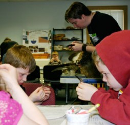 It's safe to say these students have never looked this closely at feathers before. Teacher Karen McDonald asks them to figure out what type of feather they're holding: flight, bristle, filoplume, contour, down or semi-plume. (Photo by Kirsten Bauer)