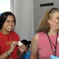 Carol Nippert of the Visitor Information and Associate Reception Center shows off the Folklife Festival logo that Caitlin Payne painted on her cheek.