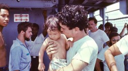On April 29, 1975, as Saigon was falling to Communist North Vietnamese forces, a small U.S. Navy destroyer escort ship, the USS Kirk, played a dramatic but almost forgotten role in rescuing up to 30,000 South Vietnamese. Here, a member of the USS Kirk's crew tends to a Vietnamese baby. (Photo by Hugh Doyle)