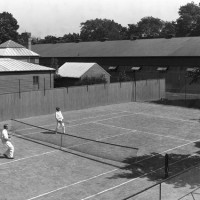 Then: In this 1920 photo by an unknown photographer, Loyal B. Aldrich of the Smithsonian Astrophysical Observatory (1908-1955) and Astrophysicist Charles Greeley Abbot (Fifth Secretary of the Smithsonian, 1928-1944) enjoy some tennis behind the Smithsonian Institution Building (the Castle), next to the Smithsonian Astrophysical Observatory, in the South Yard. The National Air Museum Quonset Hut is in the background.