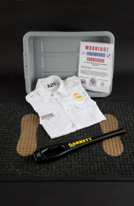 Uniform, bin, handheld metal detector d floor mat used by the Transportation Security Administration to screen airplane passengers, as part of a heightened security protocol after September 11, 2001. Photo by Richard Strauss.