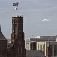 The Space Shuttle Discovery, atop a modified 747, circles the National Mall April 17, 2012. The Smithsonian Institution Building (the "Castle") is seen in the foreground. (Photo by Chun-Hsi Wong)