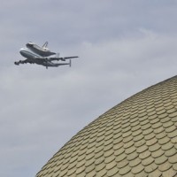 The Space Shuttle Discovery, atop a modified 747, circles the National Mall April 17, 2012. The dome of the National Museum of Natural History is seen in the foreground. (Photo by Chun-Hsi Wong)