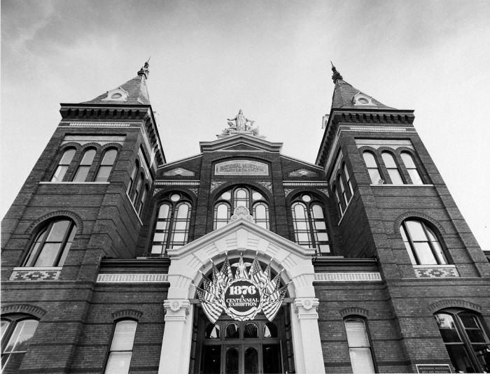 North entrance of Arts and Industries Building with a banner promoting "1876: A Centennial Exhibition" banner above doorway. The exhibit reproduced many displays from the Centennial Exposition in Philadelphia of 1876, as featured in the Torch, December 1976.