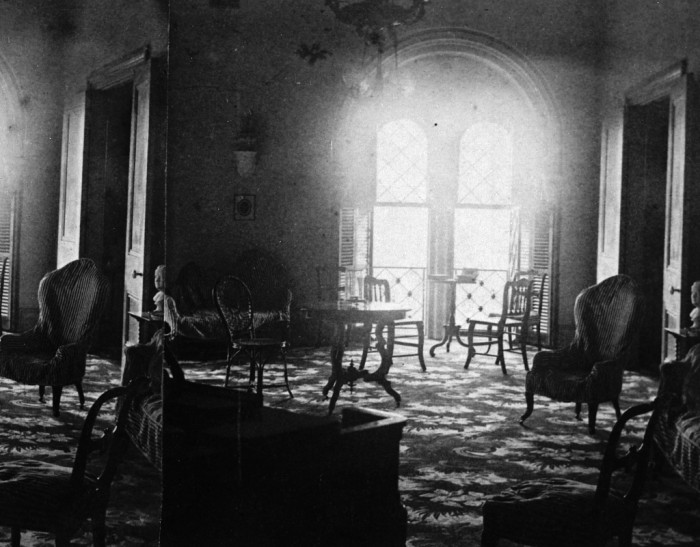 The Music Room of the Henry apartments is furnished with Rococo Revival and wicker furniture. The bust of George Washington can be seen on the far right.