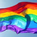 close up of Gay Pride flag against blue sky