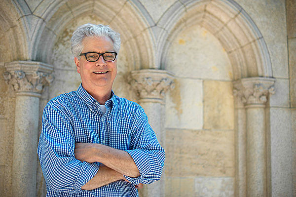 Dr. William L. Bird in front of the pedestal of the statue of Joan of Arc at Riverside Drive and 93rd Street. The pedestal is inset with stones from her dungeon, and a stone fragment is in his exhibition. (Photo by Billy Bird/New York Times)