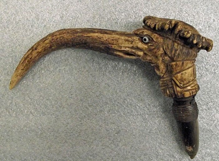 Although we don't know many specifics about this object, we do know that the museum collected it as an example of material manufacturing; the cane handle is made from elk horn. There are threads at the bottom that would allow the handle to be screwed onto a cane. When removed, another hole appeared, and the handle could become a pipe.