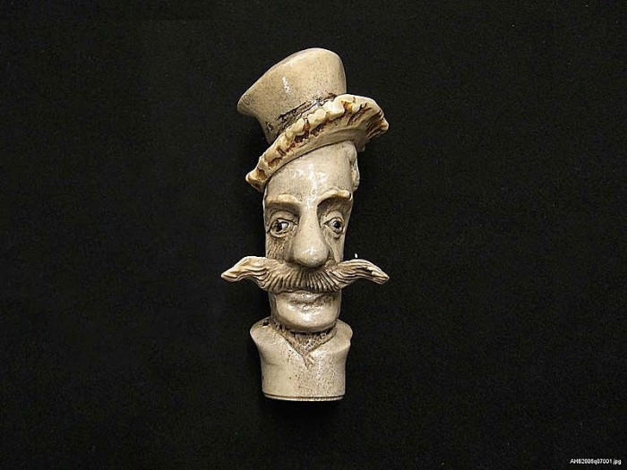 This umbrella handle, 4 ½ inches long and carved from horn, was collected in 1875 as an example of material manufacturing. A 19th century log book listing other items in the collection describes the handle as "a grotesque human head with hat, glass eyes," though we think "grotesque" is a little harsh.