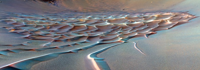 Ralph Bagnold, an early pioneer of dune studies, remarked that—compared to the nearly static chaos that seems to characterize slowly crumbling, weathering landscapes—sand dunes can “move inexorably, in regular formation, over the surface of the country, growing, retaining their shape, even breeding, in a manner which by its grotesque imitation of life, is vaguely disturbing to an imaginative mind.” Perhaps more so, if we’re on Mars? (Image: NASA/JPL-Caltech/Cornell University)