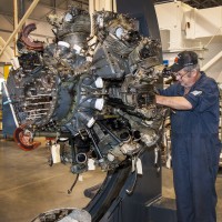 Collections specialist Scott Wood examines the engine of the Curtiss SB2C-5 Helldiver, the first aircraft to be restored in the Mary Baker Engen Restoration Hangar at the Steven F. Udvar-Hazy Center in Chantilly, VA. Collections specialists began work in early 2013 by examining, documenting, and cleaning sections of the aircraft prior to restoration. (Photo by Dale Penland)