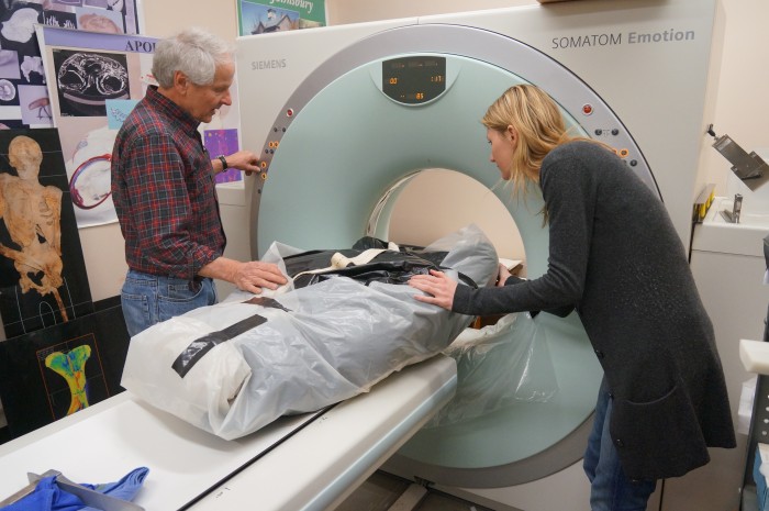 Bruno Frohlich and Sabrina Sholts guide a great ape specimen, wrapped in plastic for protection, through a CT scanner at the National Museum of Natural History. (Photo by Micaela Jemison)