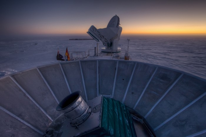 The sun sets behind BICEP2 (in the foreground) and the South Pole Telescope (in the background). (Credit: Steffan Richter)