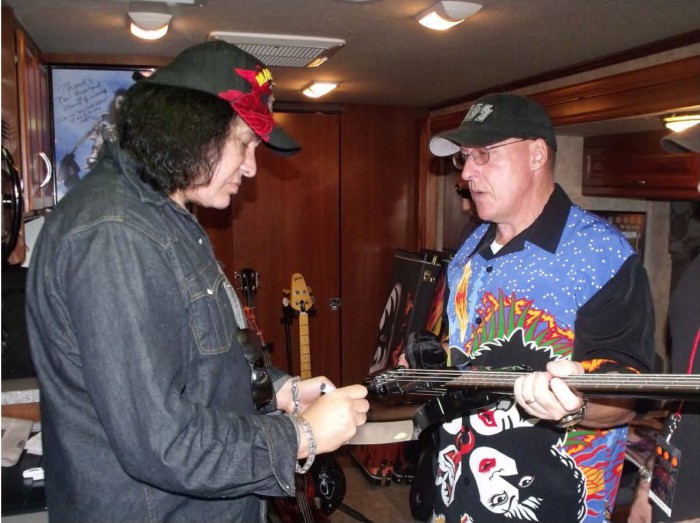 Gene Simmons autographs a guitar for John Downs