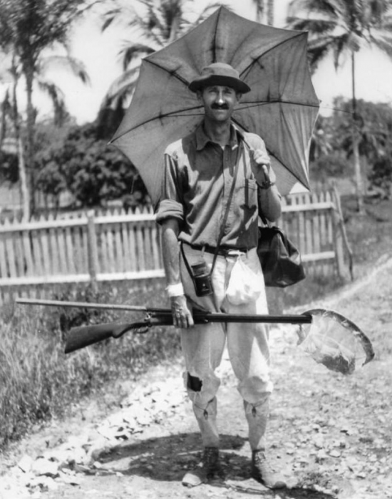 William Beebe in Guiana in 1917, holding gun and umbrella.