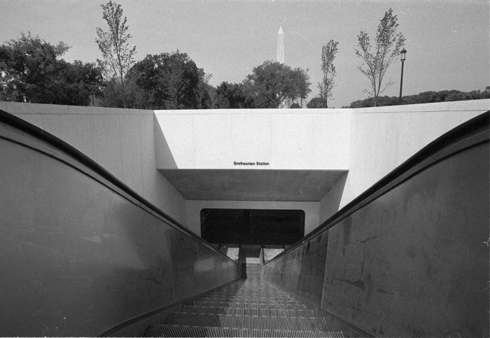 The Smithsonian Metro Station, looking down the escalators to the entrance of the terminal. The station was opened July 4, 1977. The Washington Monument is visible in the background