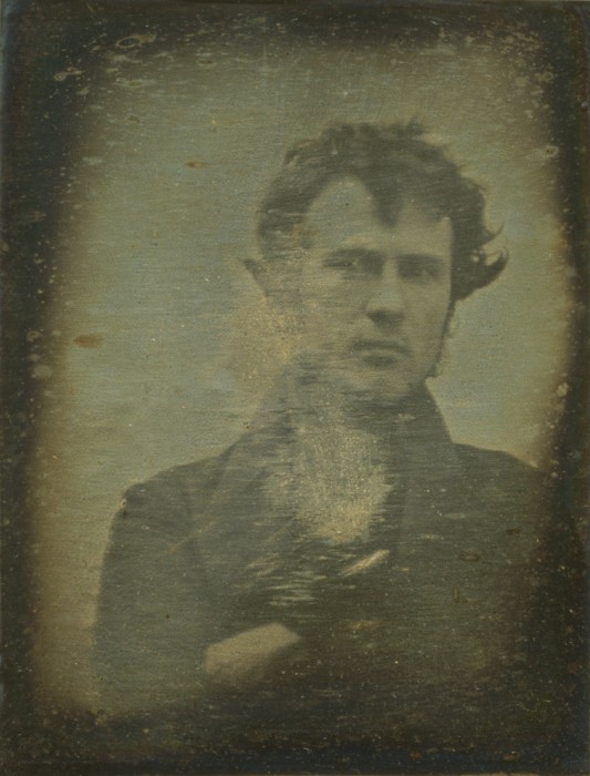 The first photographic portrait image of a human ever produced. "Robert Cornelius, head-and-shoulders [self-]portrait, facing front, with arms crossed", approximate quarter plate daguerreotype, 1839 via The Library of Congress.