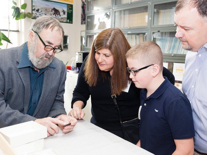 Ten-year-old Noah Cordle visited the National Museum of Natural History on November 3 to donate a Clovis point he found in New Jersey. He and his parents (right) met with the museum's Dennis Stanford (left). (Photo by Donald E. Hurlbert)