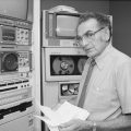 Nazaret ("Chic") Cherkezian, 1924-1996, director of Office of Telecommunications from 1976 until his retirement in 1986., stands beside equipment in Smithsonian Institution's OTC. Cherkezian's Smithsonian career began in 1974 when he became Telecommunications Coordinator for the Office of Public Affairs. Named Director of the Office of Telecommunications upon its creation in 1976, he was responsible for the Smithsonian's radio, television, and film productions until his retirement in 1986