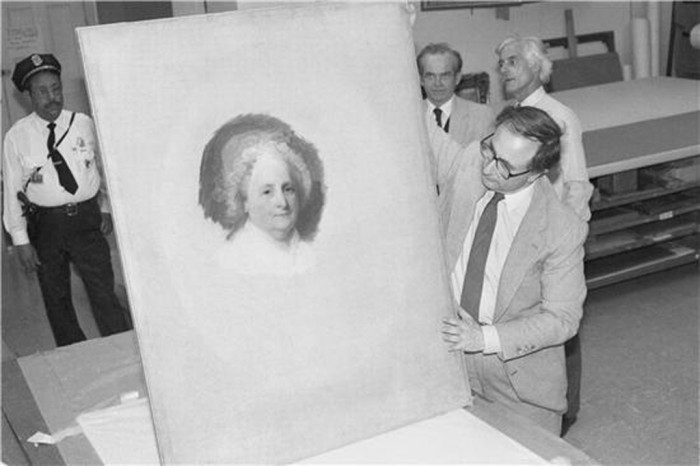 National Portrait Gallery Director Marvin Sadik of the National Portrait Gallery inspects the portrait of Martha Washington by Gilbert Stuart upon its arrival at the Gallery in 1980. (Photographer unknown)