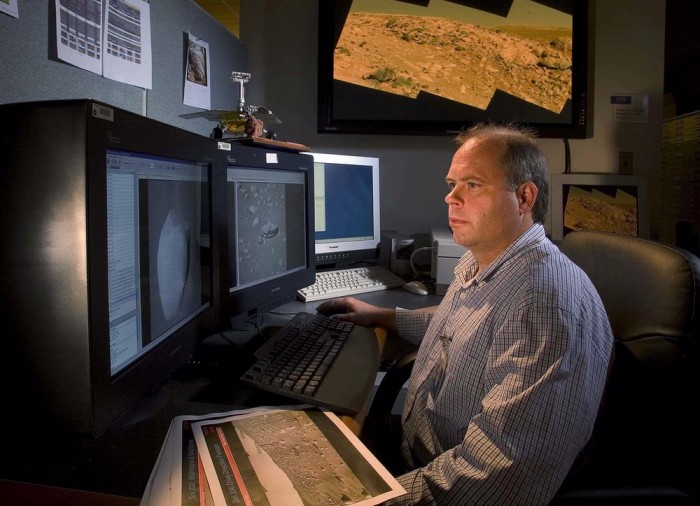 In his office at the National Air and Space Museum John Grant studies digital photographs taken by NASA rovers of the surface of Mars. (Photo by Eric Long)