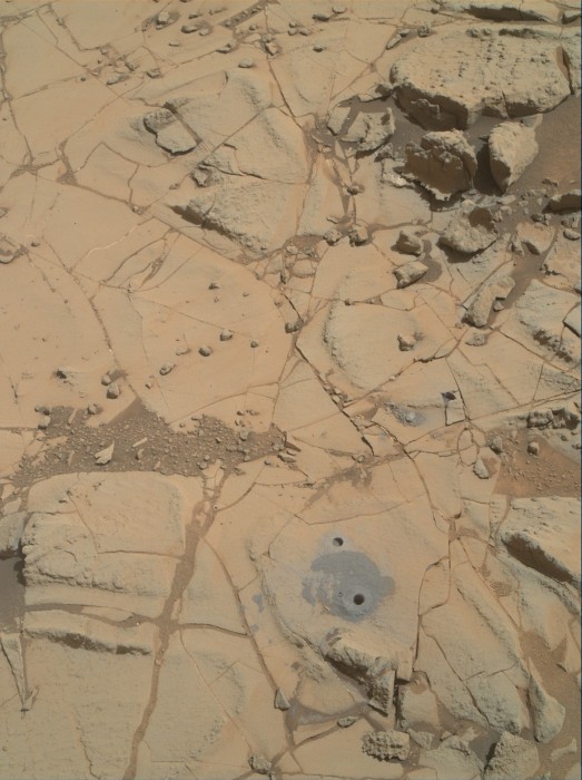 Gray cuttings from drilling by NASA’s Curiosity Mars rover into a target called “Mojave 2″ are visible surrounding the sample-collection hole in this image from the rovers’ Mars Hand Lens Imager (MAHLI) camera. This site in the “Pink Cliffs” portion of the “Pahrump Hills” outcrop provided the mission’s second drilled sample of layered rock forming the base of Mount Sharp.