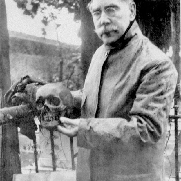 The U.S. Consul to Genoa, William Henry Bishop, holding Smithson's skull during the exhumation of his tomb. (Photo by Mabel Bell, 1904)