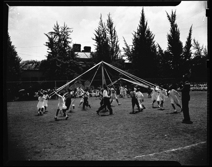 Afircan American children dance around a maypole