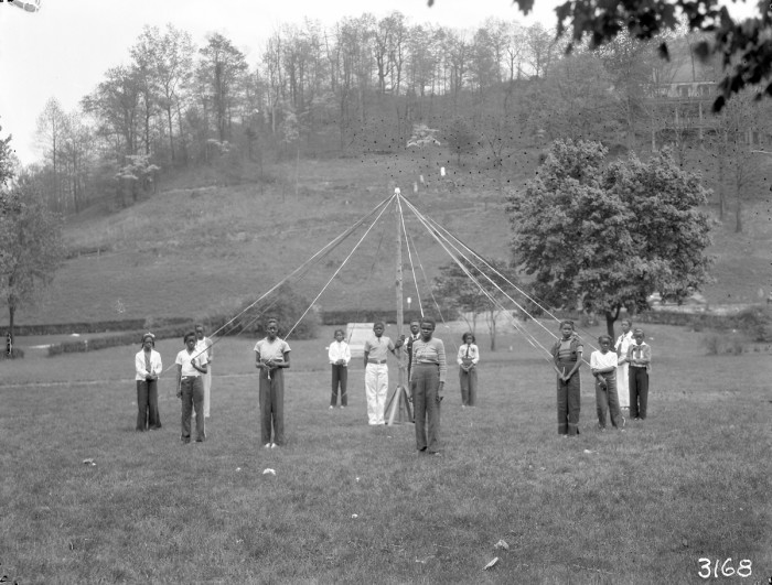 African American boys around stand around a maypole