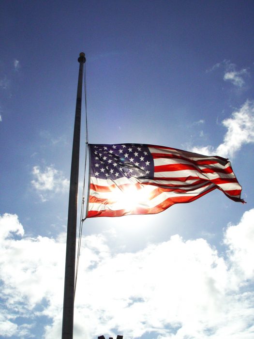 Flag at half mast against sky