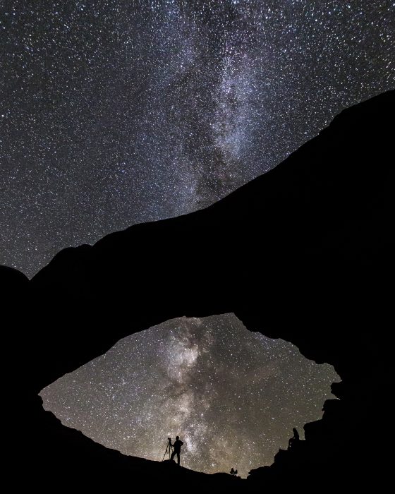 Photgrapher silhouetted against starry sky