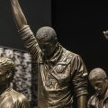 cropped photo of bronze statue of athletes with fists raised