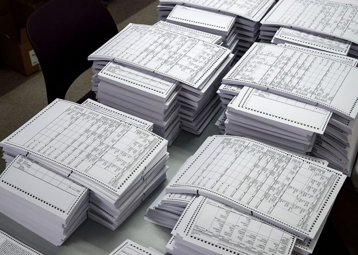 Stacks of paper ballots on table