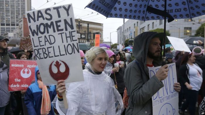 Woman dressed as Princess Leia holding sign