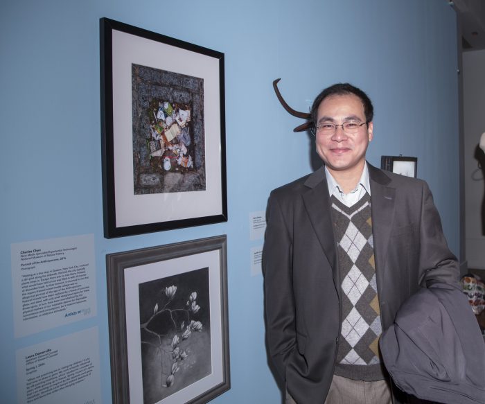 Artist with his work in gallery exhibition.