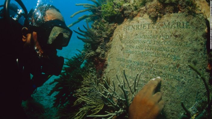 Scuba diver reads underwater inscription