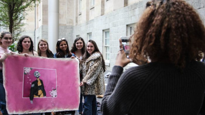 Women holding banner pose for photo