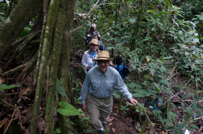 Dr Skorton in lead, Dr Davisson behind as they climb a forest trail.