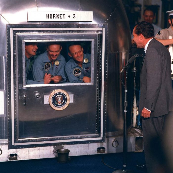 Astronauts talkj to Nixon through capsule hatch