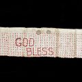 hand-stiched sash with God Bless embroidered on it
