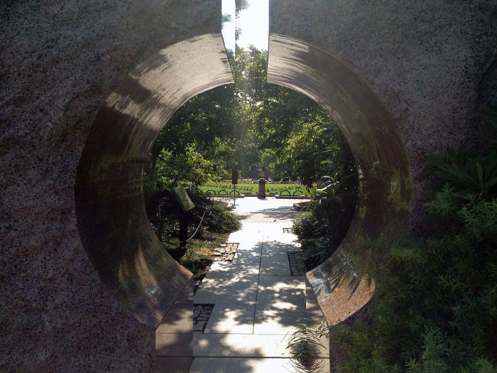 Urn viewed through circular opening of granite moon gate