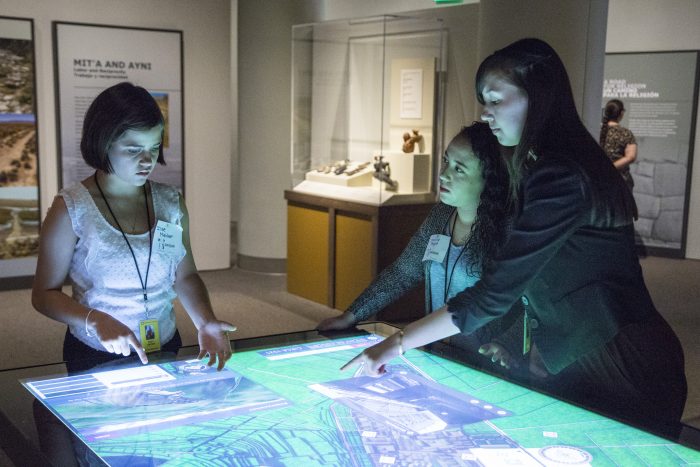 students gathered around lighted display table