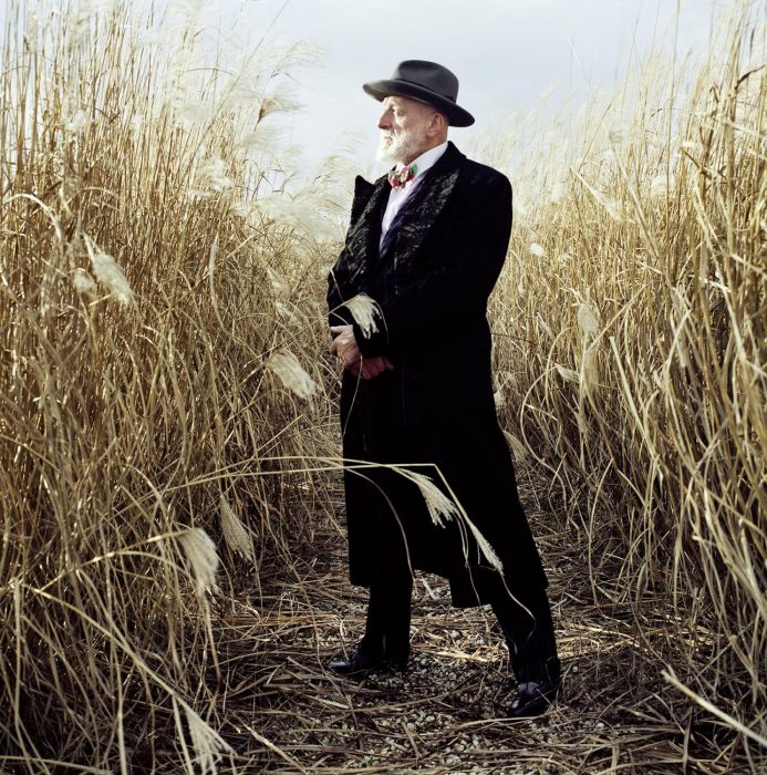 Formally dressed bearded man standing in a cornfield