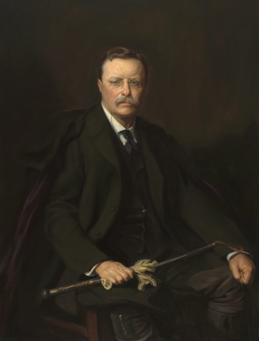 Portrait of Theodore Roosevelt holding riding crop and gloves