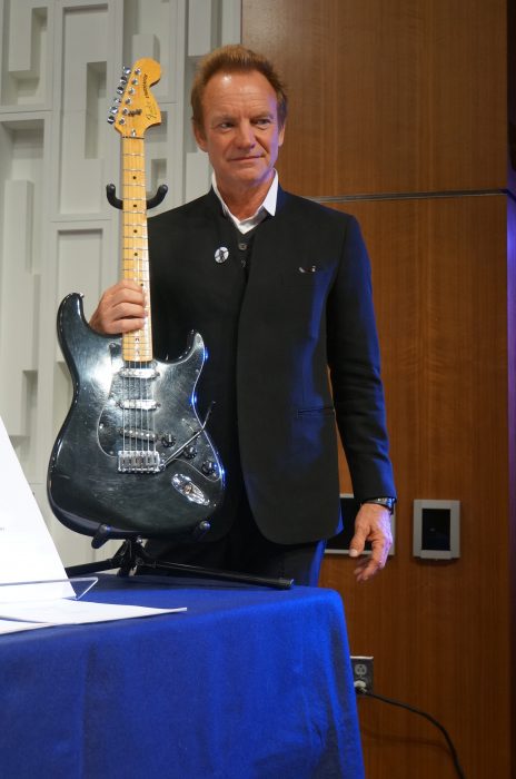 Sting holding guitar
