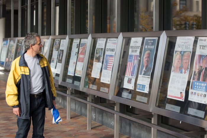 Man looks at display of newspapers